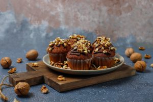 chocolate-walnut-muffins-with-coffee-cup-with-walnuts-dark-surface